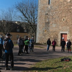 Randonneurs écoutant les guides au pied d&#039;une tour
