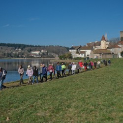 Randonneurs devant un étang sous un ciel bleu