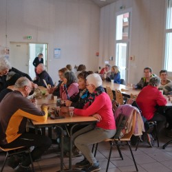 Randonneurs dans une salle en train de boire et grignotter