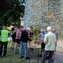 Des randonneurs autour d&#039;une table en train de boire et grignoter, à l&#039;ombre