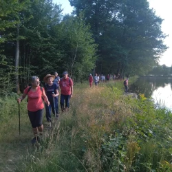 Randonneurs en marche le long d&#039;un étang sur la droite