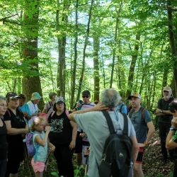Des personnes jeunes ou moins, avec casquette ou sans, lors d'une pause à l'ombre des arbres.